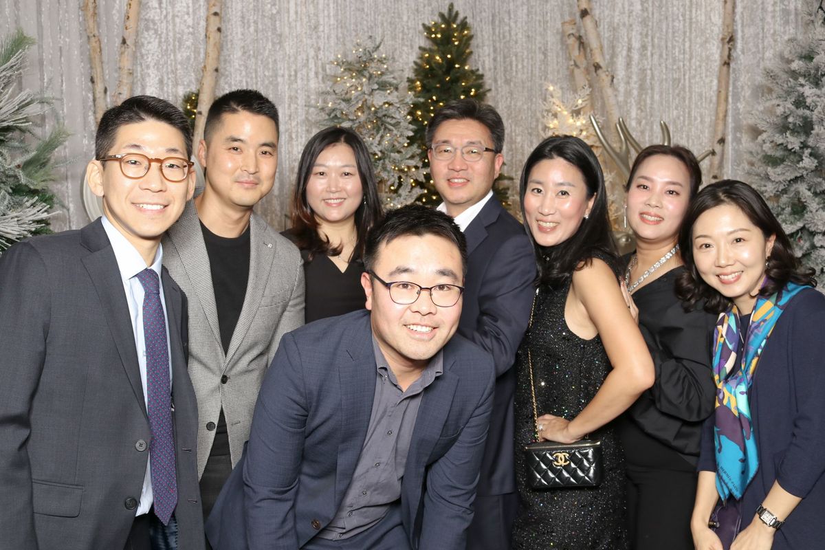 Colleagues at a corporate holiday party in front of a backdrop of birch branches and snowy trees